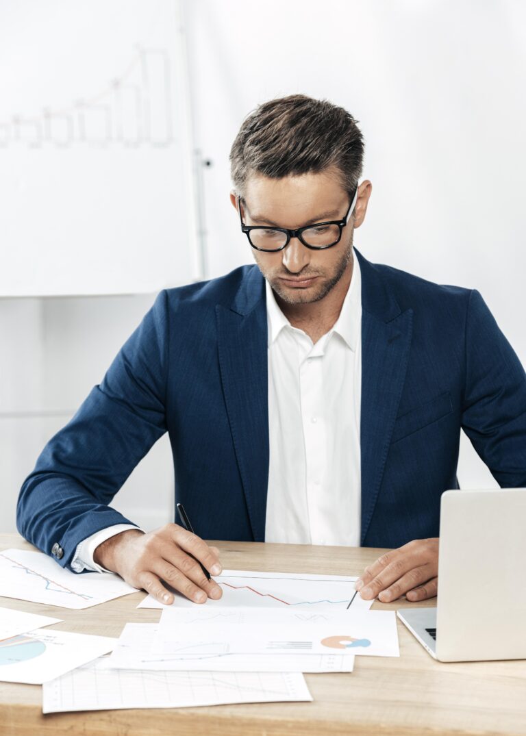 Professional financial advisor reviewing annuity contract documents and financial charts on desk - representing expert guidance on surrender charges and market value adjustments in guaranteed lifetime income annuities
